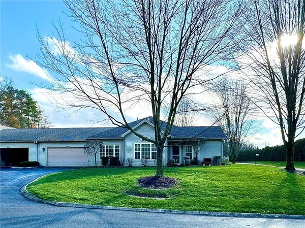 a front view of a house with a garden and trees