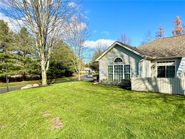 a view of a house with a big yard and large trees