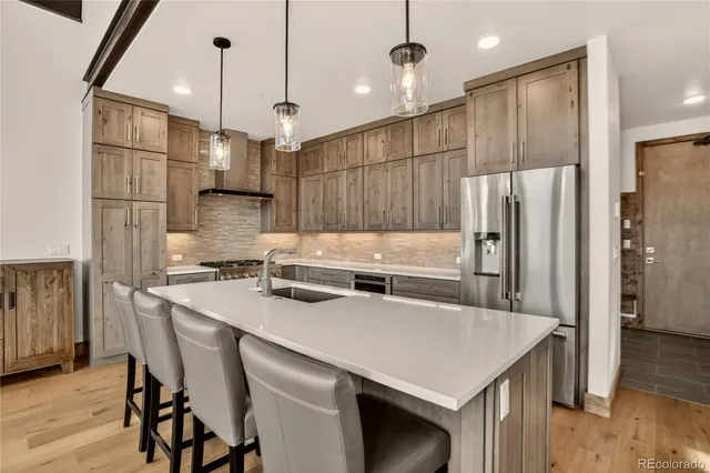 a kitchen that has a cabinets a sink and a stove with wooden floor