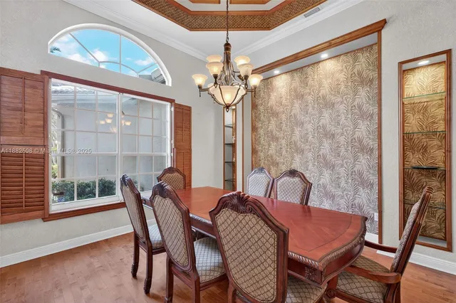 a dining room with furniture a chandelier and wooden floor