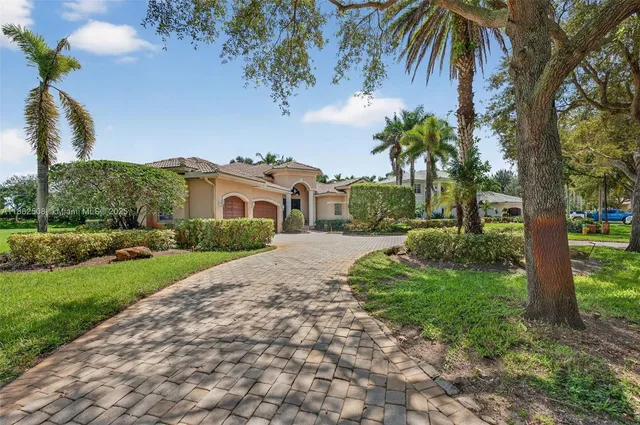 a view of a white house with a yard and potted plants