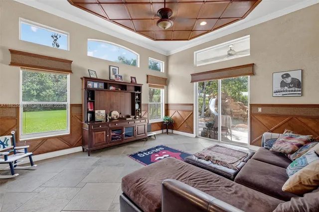 a living room with furniture and a floor to ceiling window