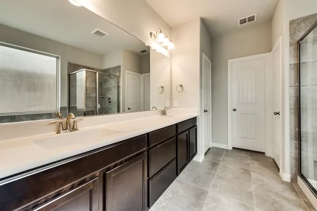 a spacious bathroom with a double vanity sink a mirror and a bathtub
