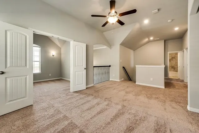a view of a livingroom with a ceiling fan and kitchen space