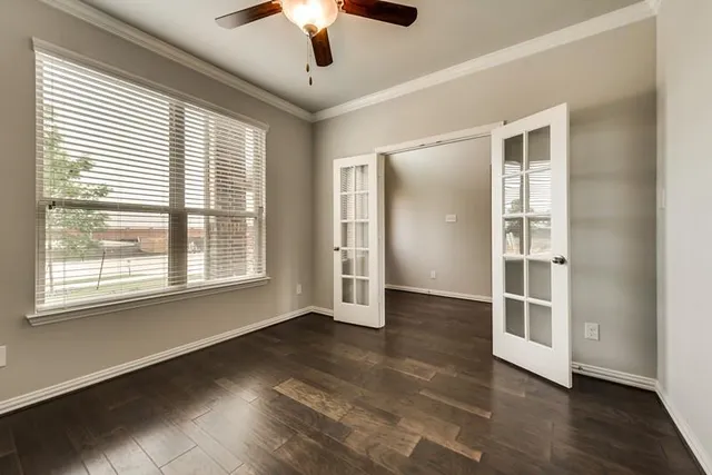 a view of an empty room with a window and wooden floor