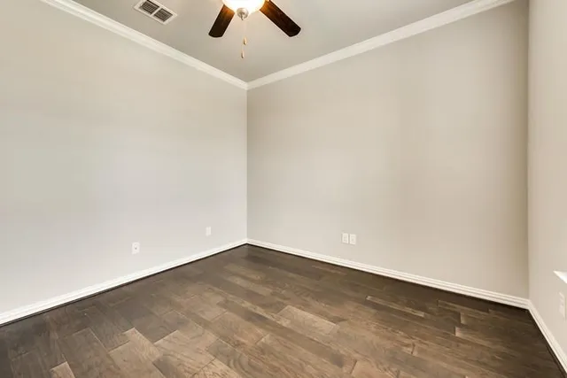 an empty room with a ceiling fan and carpet