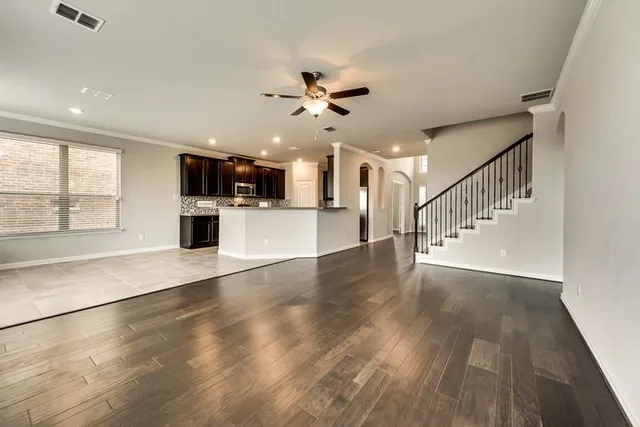 a view of an empty room with window and wooden floor