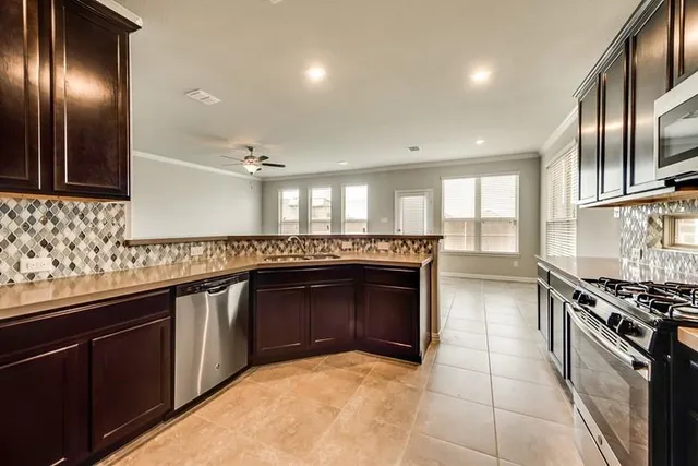 a kitchen with stainless steel appliances granite countertop a stove a sink and a refrigerator