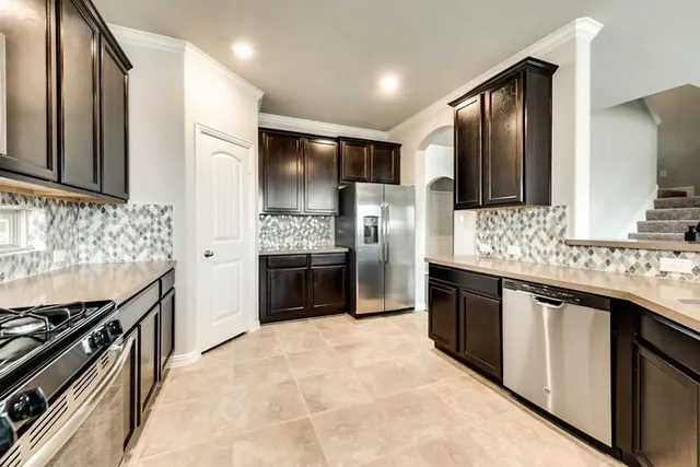 a large kitchen with stainless steel appliances and cabinets