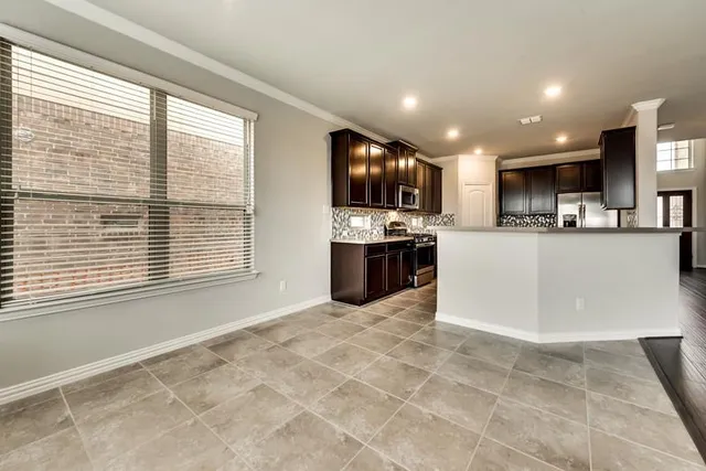 a large kitchen with cabinets and a flat screen tv
