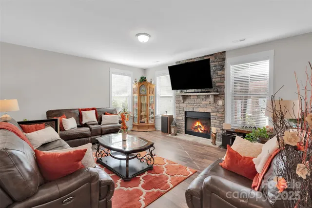 a living room with furniture a fireplace and a flat screen tv