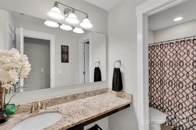 a bathroom with a granite countertop sink a large mirror and vanity