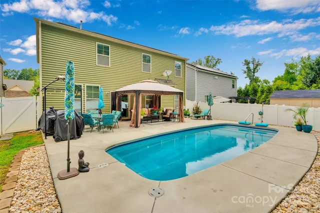 a view of a house with swimming pool and sitting area