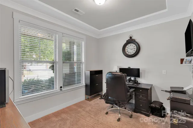 a view of a workspace with furniture and a window