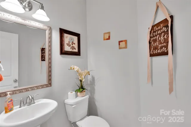 a bathroom with a sink mirror and toilet