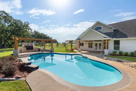 a swimming pool with outdoor seating yard and barbeque oven