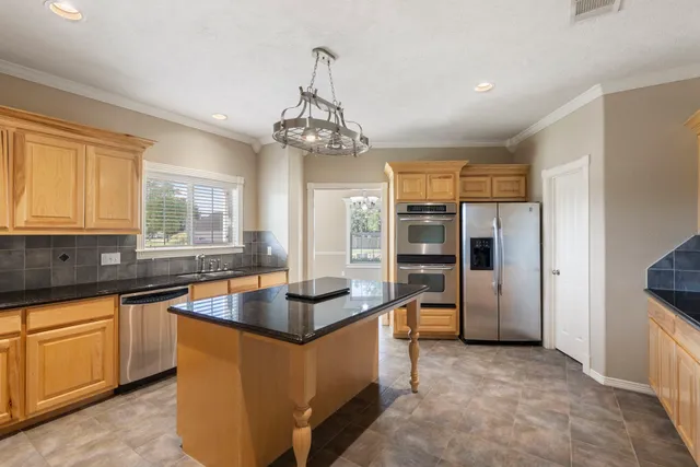 a kitchen with stainless steel appliances granite countertop a sink refrigerator and cabinets