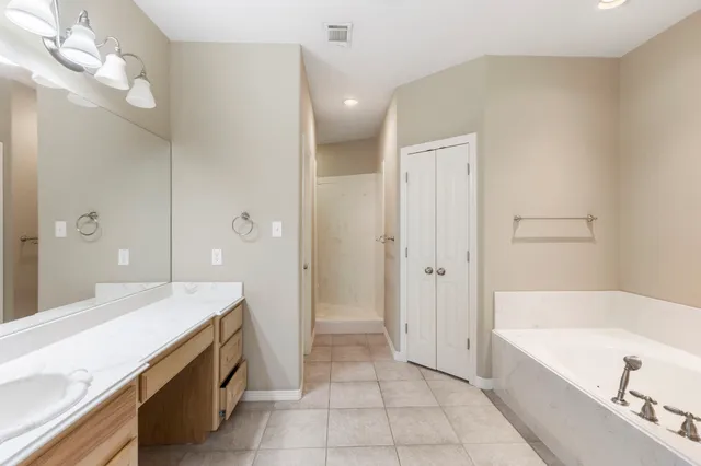 a spacious bathroom with a tub sink and mirror