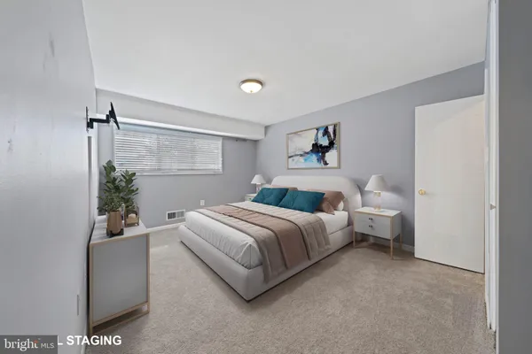 a spacious bedroom with a bed and a potted plant