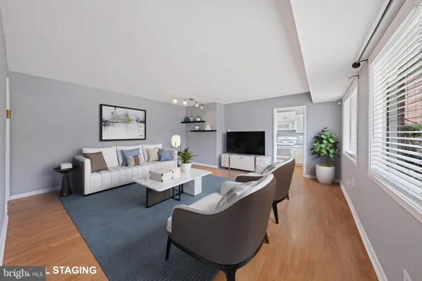 a living room with furniture a flat screen tv and a large window