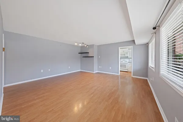 wooden floor in an empty room with a kitchen