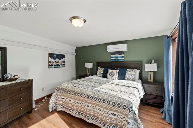 a bedroom with a bed and a lamp on dresser