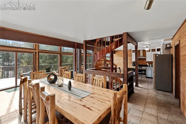 a view of a dining room with furniture large windows and a chandelier