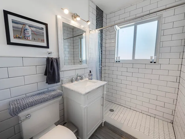 a bathroom with a sink a toilet and shower