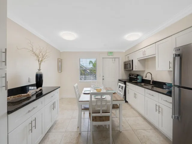 a large kitchen with granite countertop a sink and cabinets