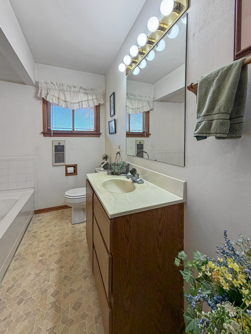 6057 North Lake Road Lena, IL 61048 - Photo 16 of 22 a bathroom with a sink a mirror and a shower