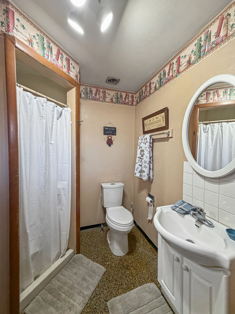 6057 North Lake Road Lena, IL 61048 - Photo 18 of 22 a bathroom with a sink toilet and shower