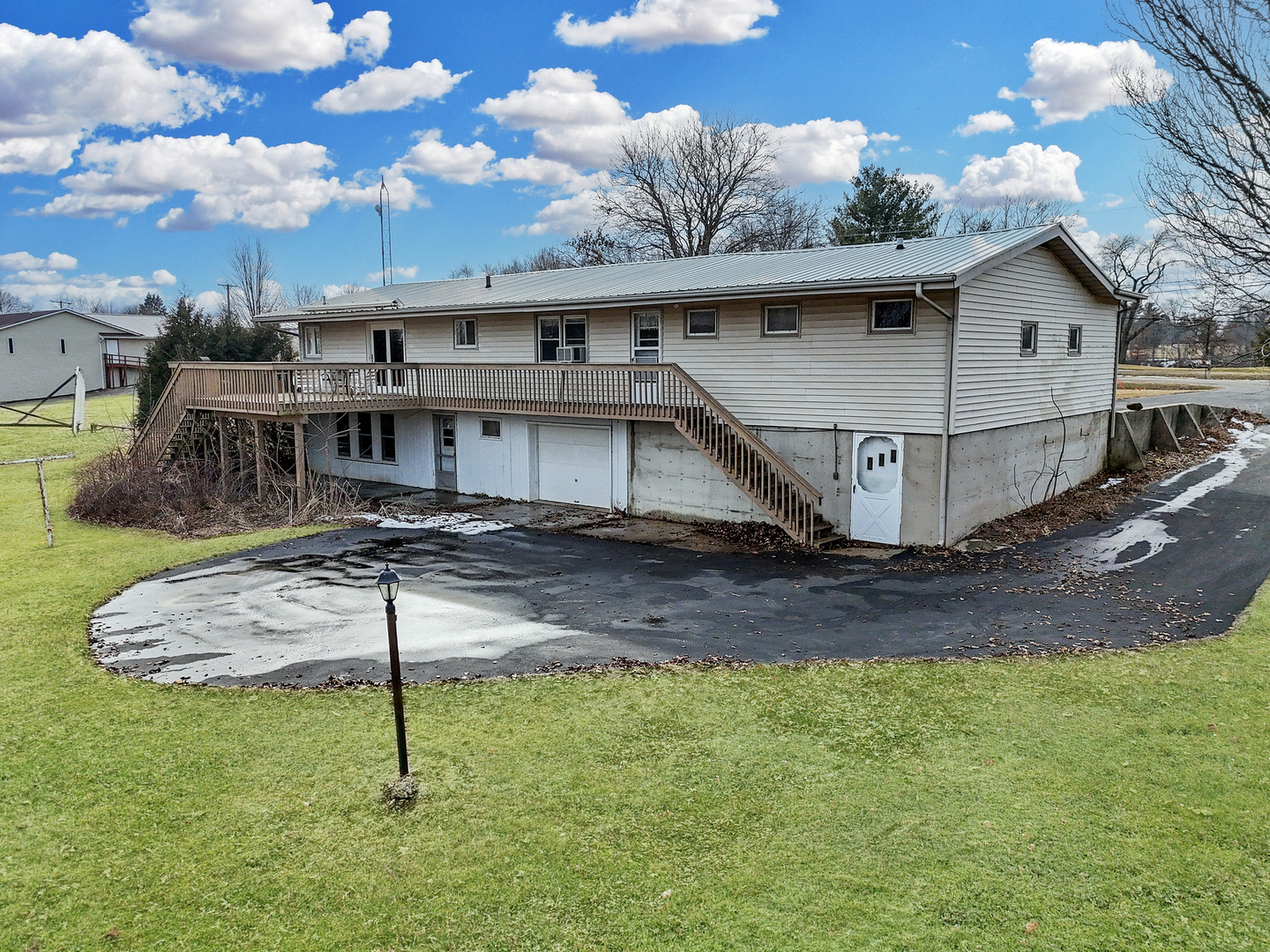 6057 North Lake Road Lena, IL 61048 - Photo 2 of 22 a view of a white house with a yard plants and large tree