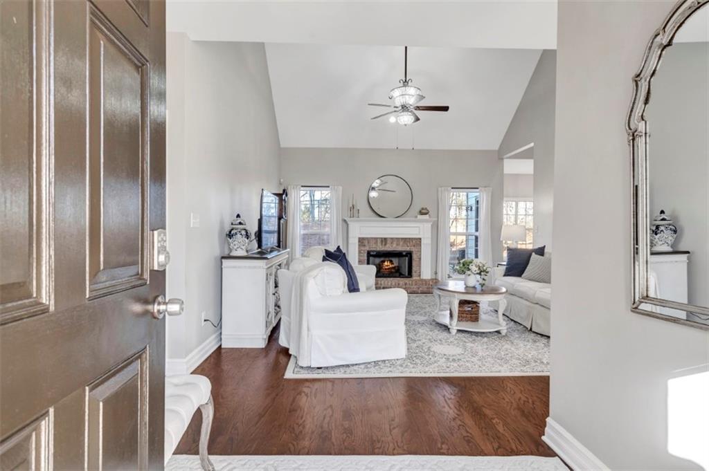 1075 Julius Drive Suwanee, GA 30024 - Photo 2 of 21 a living room with furniture a fireplace and a chandelier