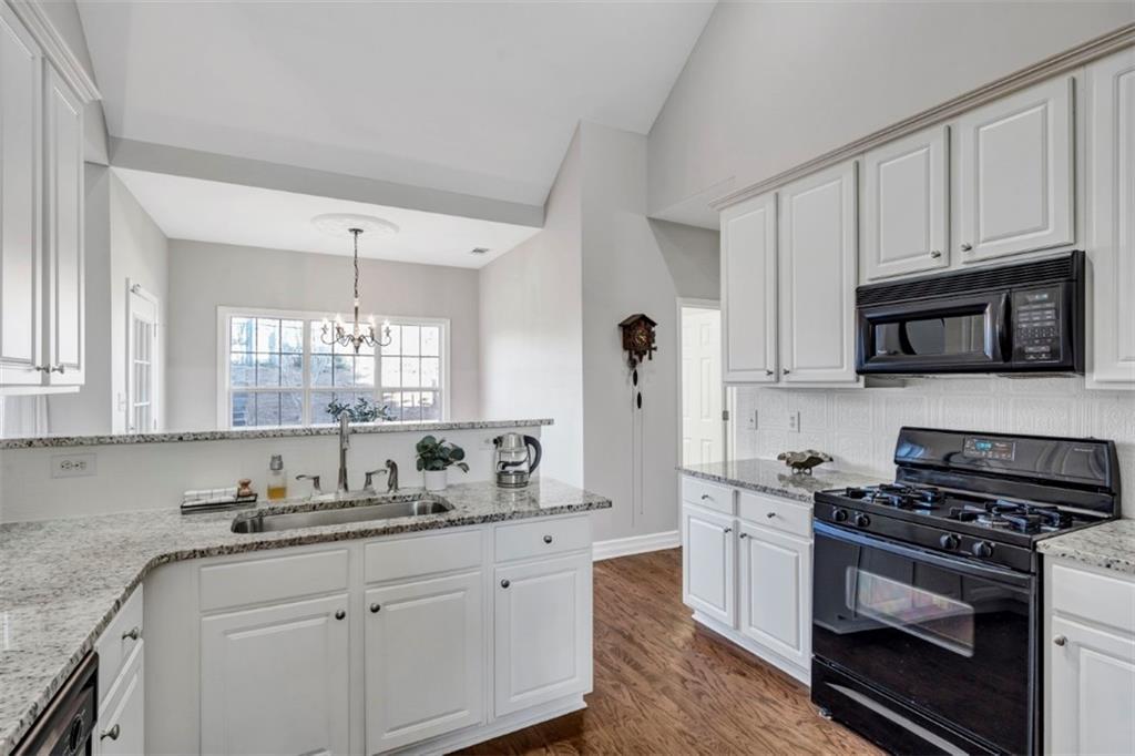 1075 Julius Drive Suwanee, GA 30024 - Photo 7 of 21 a kitchen with granite countertop white cabinets white stainless steel appliances and sink