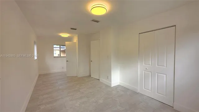 an empty room with windows and wooden floor