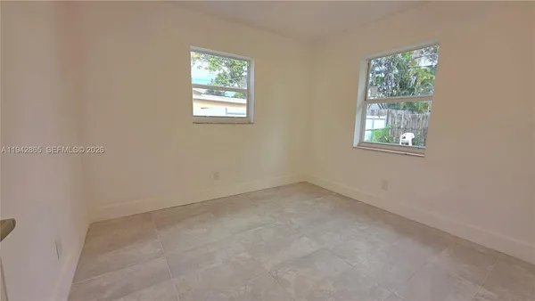 a view of a hallway with wooden floor and windows