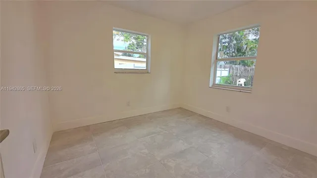 a view of a hallway with wooden floor and windows