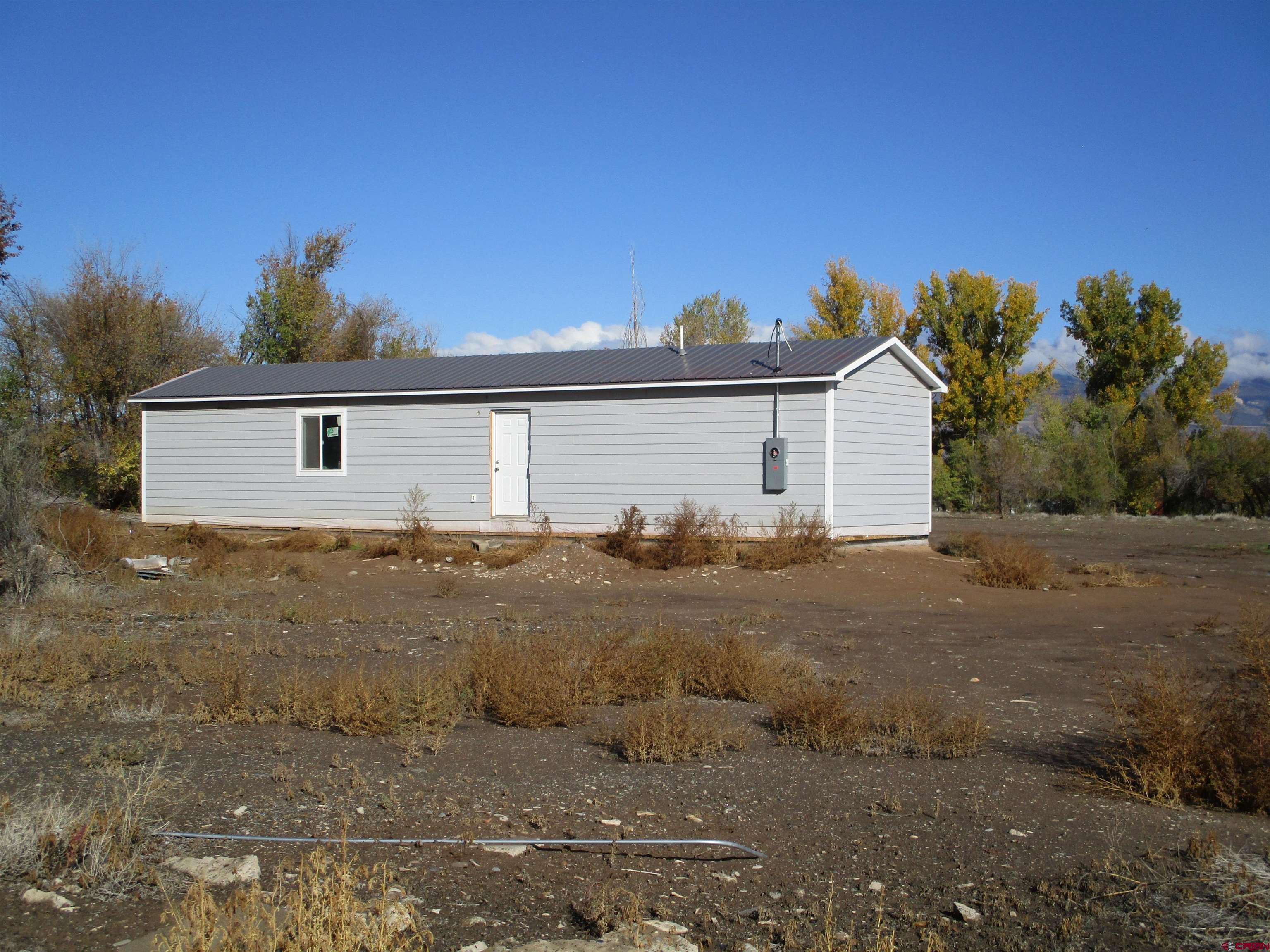 1175 East 3rd Common Delta, CO 81416 - Photo 1 of 2 a front view of a house with a yard