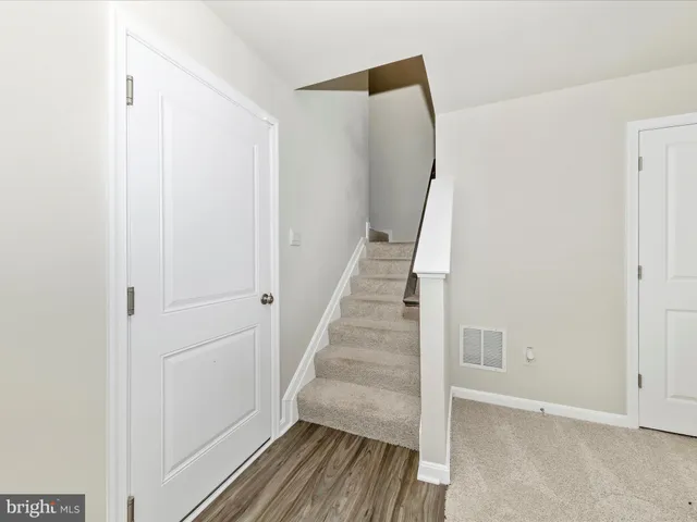 a view of a hallway with wooden floor and entryway