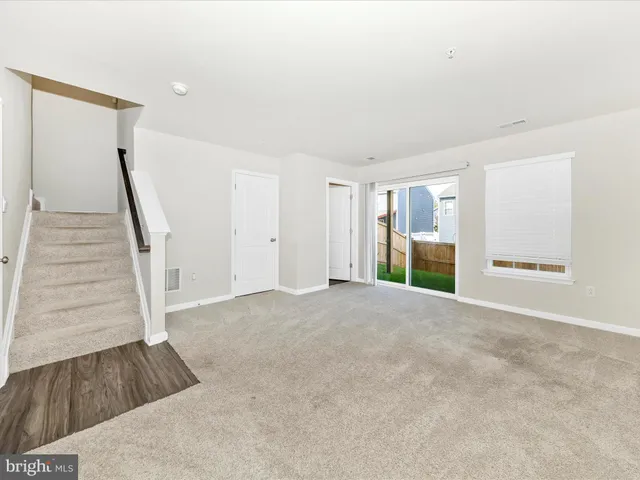 a view of an empty room with stairs and ventilation