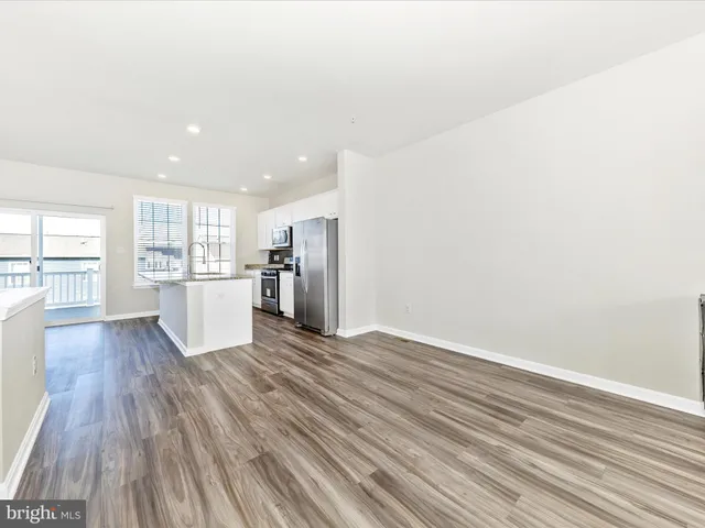 a view of a kitchen with wooden floor and a refrigerator