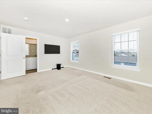 an empty room with windows and television