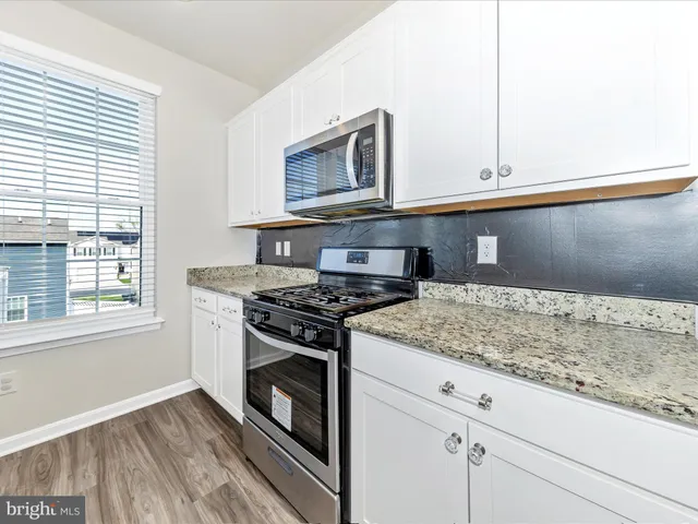 a kitchen with granite countertop a stove and a sink