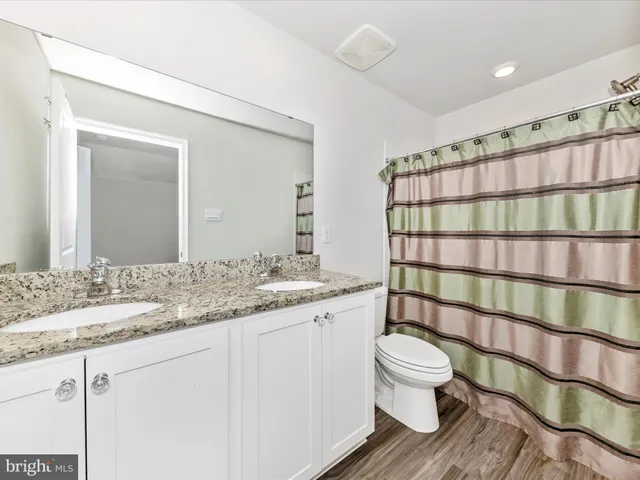 a bathroom with a double vanity sink toilet and shower