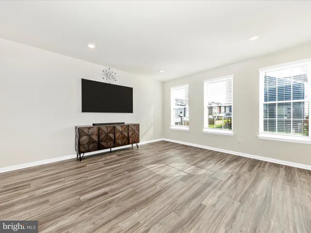 an empty room with windows and fireplace
