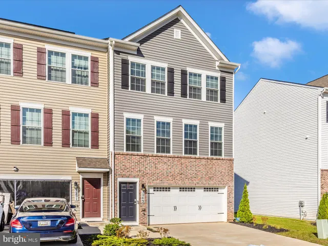 a front view of a house with cars parked