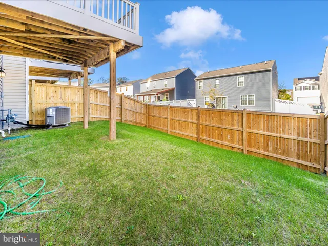 a view of a backyard with plants and wooden fence