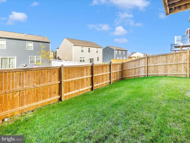 a view of a backyard with a wooden fence