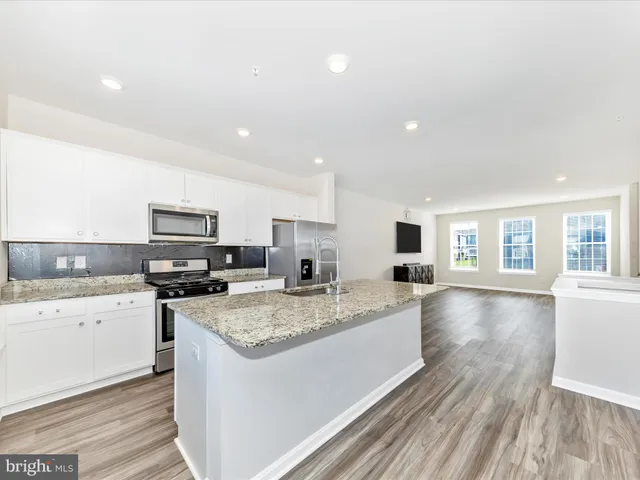 a kitchen with sink stove and microwave