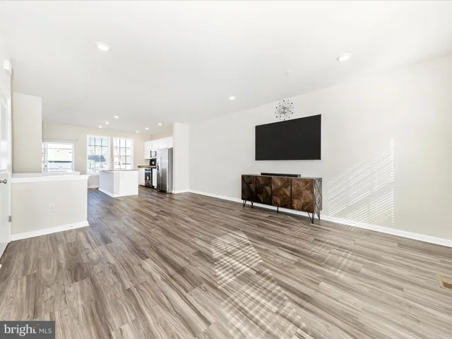 a view of a livingroom with wooden floor and a flat screen tv